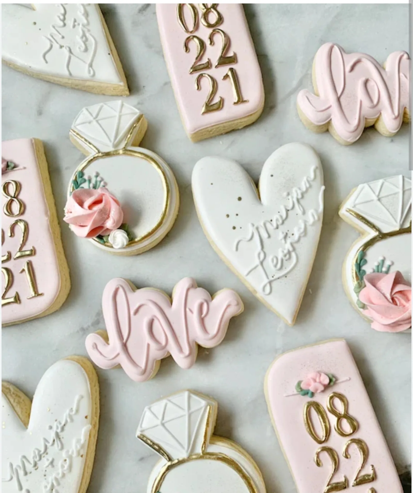 Bridal shower cookies in blush and white with diamond rings, hearts, love script and the date 08.22.21.