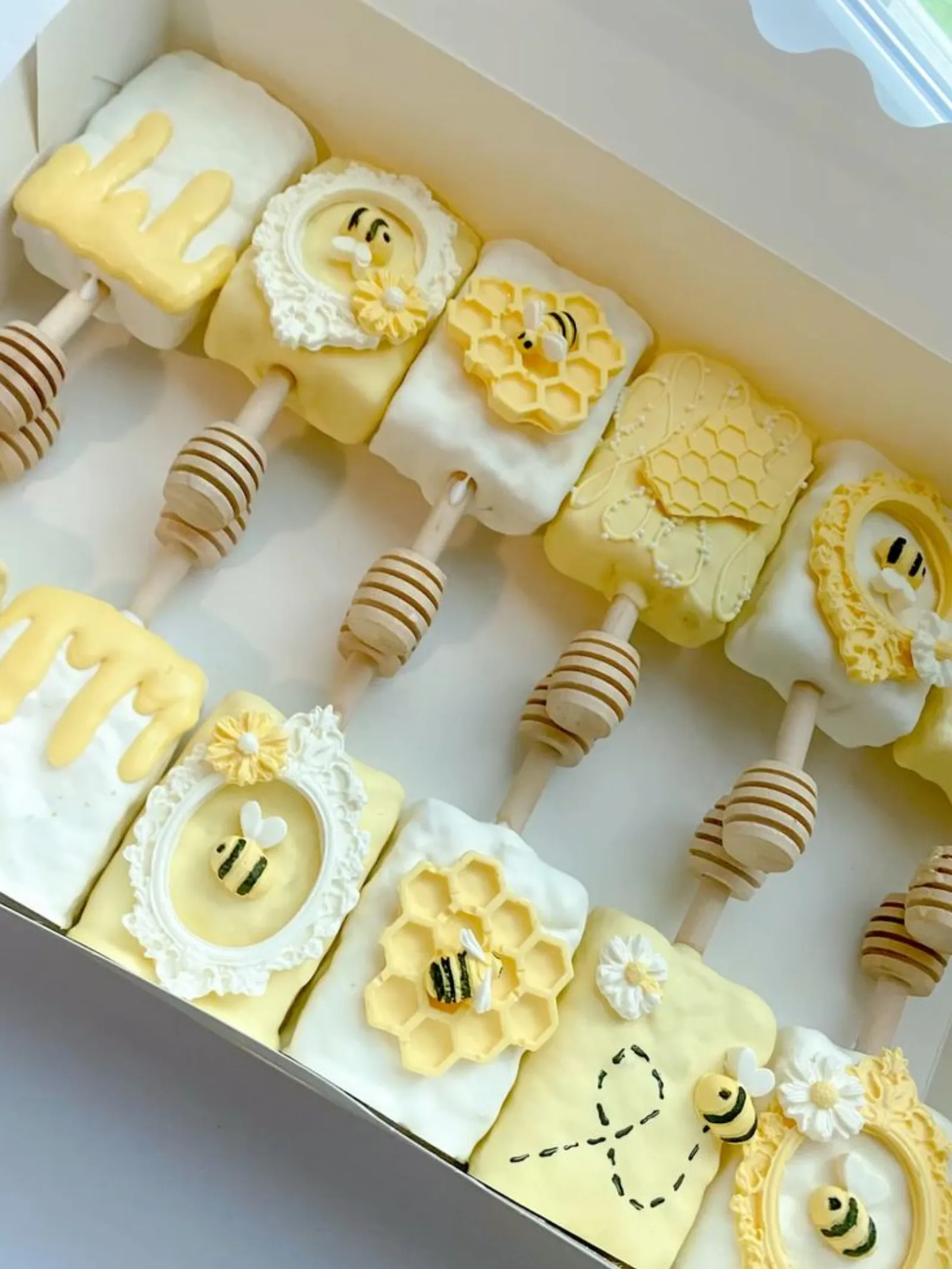 Chocolate-covered strawberries dipped in white and yellow chocolate, decorated with fondant bees and honeycomb.