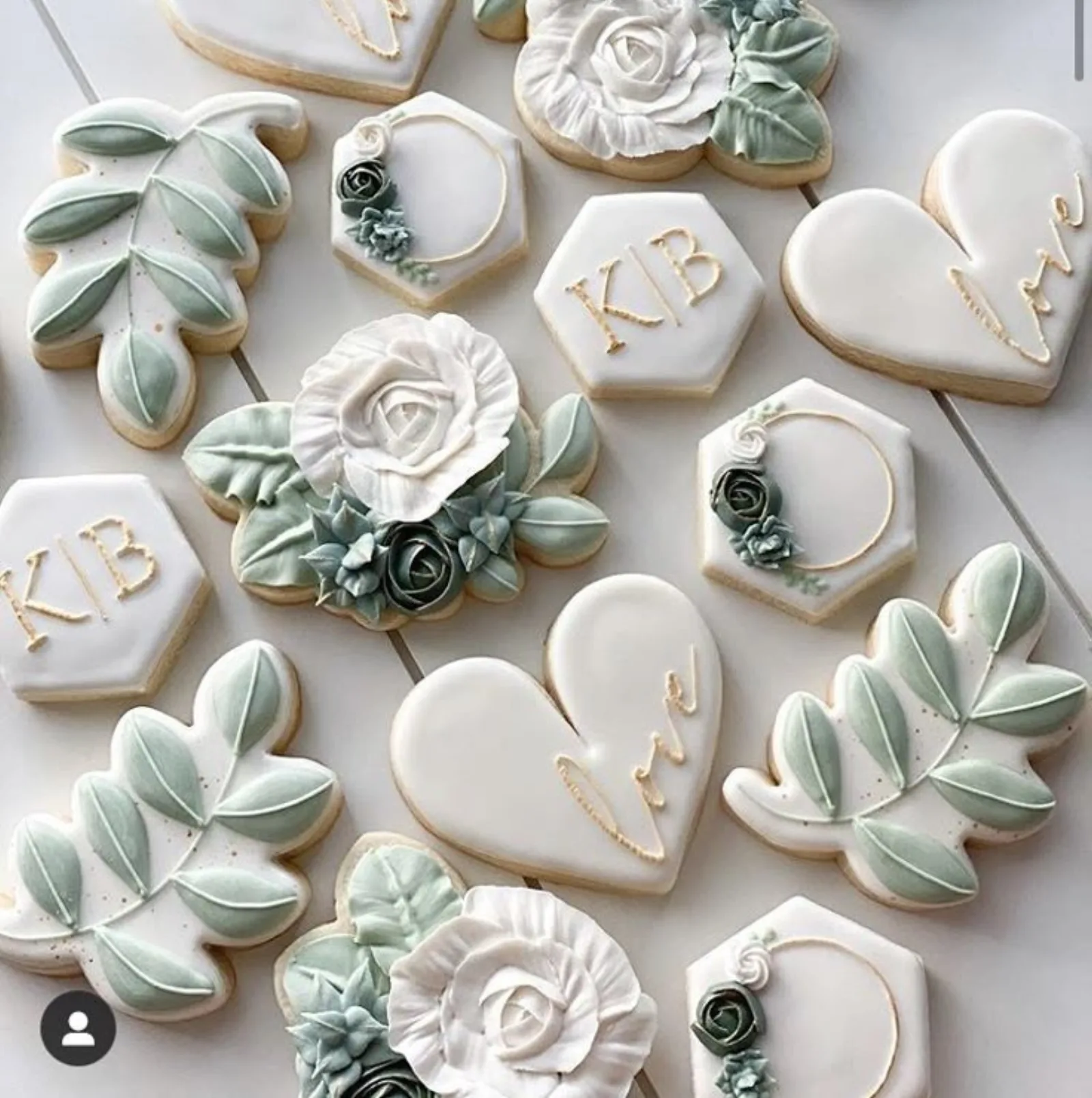 Sage and white wedding cookies with monogram hexagons, piped roses, eucalyptus leaves and love script.