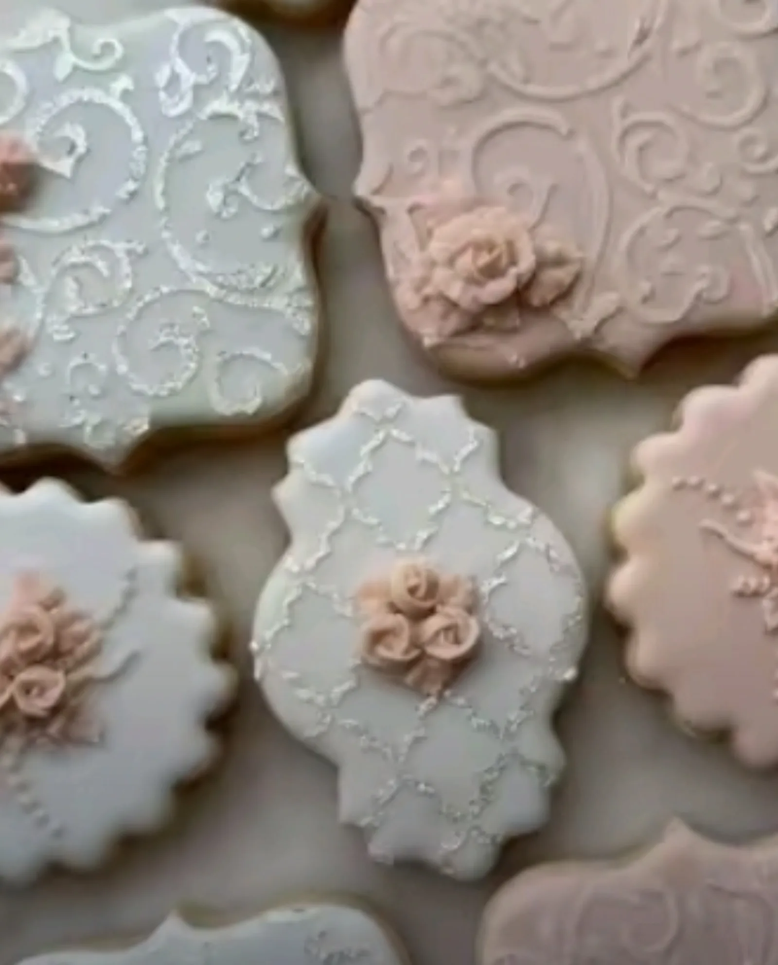 Vintage style cookies in sage and blush with piped lace, quatrefoil patterns and sugar roses.