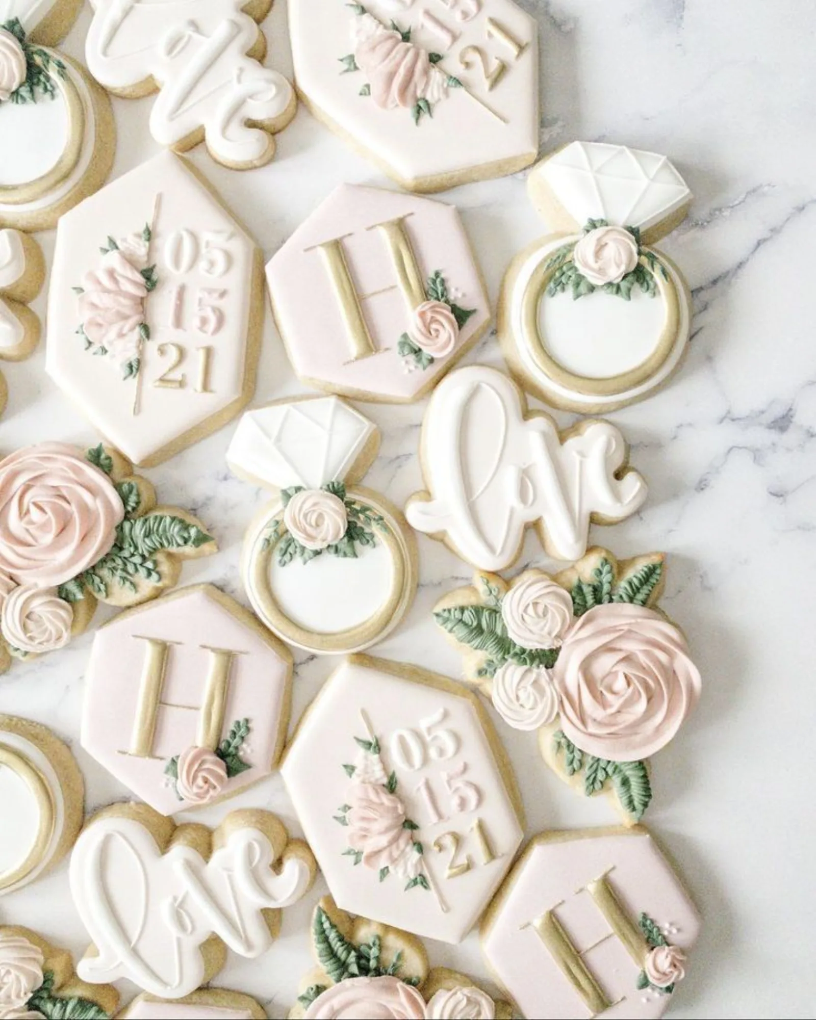 Wedding cookies in white and gold with H monograms, love script, ring shapes and floral sprays.